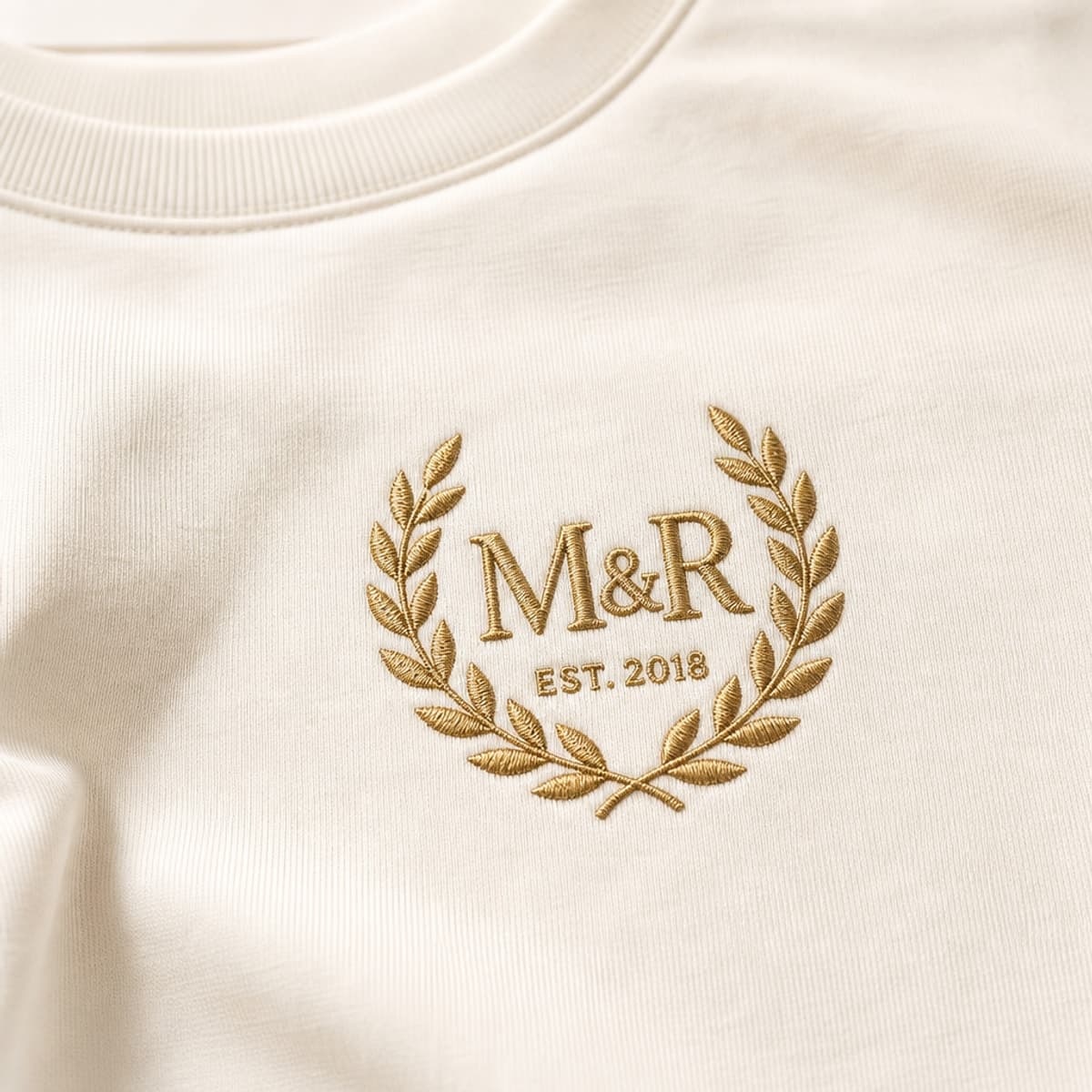 Cream tee with raised gold M&R embroidered crest