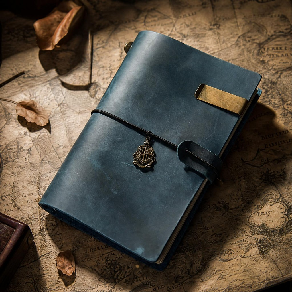 Navy journal on a sepia map with autumn leaves